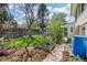 Serene backyard featuring lush lawn, vegetable garden, mature trees, and a quaint outbuilding at 14582 E Harvard Ave, Aurora, CO 80014