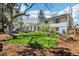 Spacious backyard featuring mature trees, a grassy lawn, garden beds, and a charming outbuilding at 14582 E Harvard Ave, Aurora, CO 80014
