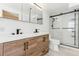 Updated bathroom featuring dual sinks, wood cabinets, and modern shower with glass door at 14582 E Harvard Ave, Aurora, CO 80014
