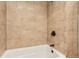 Tile surround bathtub with bronze fixtures, adding warmth and charm to the bathroom space at 14582 E Harvard Ave, Aurora, CO 80014