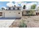 Charming home featuring a white brick exterior, two-car garage, and meticulous landscaping at 14582 E Harvard Ave, Aurora, CO 80014