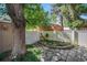 Picturesque backyard featuring a stone patio, lush garden, and a decorative rooster figurine by the white fence at 1419 N Adams St, Denver, CO 80206