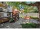 Charming backyard featuring a stone patio, wooden deck, comfortable seating, and a swing hanging from a mature tree at 1419 N Adams St, Denver, CO 80206