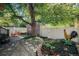 Charming backyard featuring a stone patio, garden bed, shade tree, and white fence, perfect for outdoor living at 1419 N Adams St, Denver, CO 80206