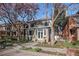Charming two-story home featuring a lovely landscaped front yard with blooming trees and a stone walkway at 1419 N Adams St, Denver, CO 80206