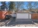 Exterior view featuring a two-car garage, additional parking space, and backyard fence for added privacy at 1419 N Adams St, Denver, CO 80206