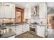 Well-lit kitchen featuring white cabinets, stainless steel appliances, and herringbone floors at 1419 N Adams St, Denver, CO 80206