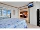 Bright bedroom features an entertainment system and an open doorway to the kitchen and living room at 3100 E Cherry Creek South Dr # 1507, Denver, CO 80209