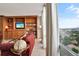 Cozy living room featuring a custom built-in entertainment center, comfortable seating, and panoramic city views at 3100 E Cherry Creek South Dr # 1507, Denver, CO 80209