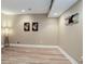 A finished basement area with neutral walls, wood-style flooring, recessed lighting, and decorative accents at 24621 E Berry Pl, Aurora, CO 80016