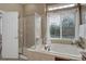 Bathroom with a glass-enclosed shower and a tub under a window with decorative curtains at 24621 E Berry Pl, Aurora, CO 80016