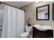 Standard bathroom featuring a shower with curtain, toilet, sink, dark vanity, mirror, and a neutral color scheme at 24621 E Berry Pl, Aurora, CO 80016