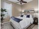 Comfortable bedroom featuring a cozy bed, a house plant, a window, and lake themed wall art at 24621 E Berry Pl, Aurora, CO 80016