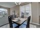 Dining room with a dark wood table, modern chairs, and ample natural light from a large window at 24621 E Berry Pl, Aurora, CO 80016