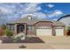 Charming brick home featuring an attached three-car garage, arched entryway, and landscaped front yard at 24621 E Berry Pl, Aurora, CO 80016