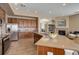 Spacious kitchen with stainless steel appliances, granite countertops, and wood cabinets, leading to a cozy fireplace at 24621 E Berry Pl, Aurora, CO 80016