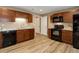 Efficient kitchen area featuring dark cabinets, granite countertops, and wood-look flooring at 24621 E Berry Pl, Aurora, CO 80016
