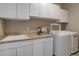 Functional laundry room features a sink, storage cabinets, and a washer and dryer at 24621 E Berry Pl, Aurora, CO 80016