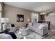 Bright living room with neutral paint, modern furnishings, and an archway leading to the dining area at 24621 E Berry Pl, Aurora, CO 80016