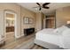 Spacious main bedroom with wood floors, neutral walls, a ceiling fan, and ensuite bathroom access at 24621 E Berry Pl, Aurora, CO 80016
