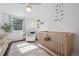 Light-filled bedroom with hardwood floors, crib, and a charming chair at 8981 E Amherst Dr # E, Denver, CO 80231