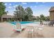 Large community pool surrounded by lounge chairs, tables, and well-maintained landscaping at 8981 E Amherst Dr # E, Denver, CO 80231