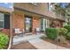 Inviting brick porch with seating, creating a welcoming entrance with mature landscaping at 8981 E Amherst Dr # E, Denver, CO 80231