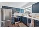 Updated kitchen featuring stainless steel appliances, subway tile backsplash, and blue cabinets at 8981 E Amherst Dr # E, Denver, CO 80231