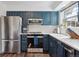 Kitchen features stainless steel appliances, dark blue cabinetry, and white subway tile backsplash at 8981 E Amherst Dr # E, Denver, CO 80231