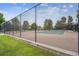Community tennis court behind chain link fence with well-kept court and new net at 8981 E Amherst Dr # E, Denver, CO 80231