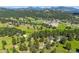 An aerial view of the neighborhood surrounded by lush trees, scenic mountains, and green meadows at 29263 Sue Rd, Evergreen, CO 80439