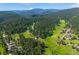 A beautiful aerial view of a neighborhood surrounded by lush green meadow and forest at 29263 Sue Rd, Evergreen, CO 80439