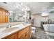 Modern bathroom featuring double sinks, decorative mirror, sleek fixtures, tub, and glass enclosed shower at 29263 Sue Rd, Evergreen, CO 80439