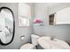 Cozy bathroom featuring a modern sink, toilet, oval mirror, and natural light from the adjacent window at 29263 Sue Rd, Evergreen, CO 80439