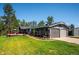 Charming home exterior featuring a two-car garage, manicured lawn, and inviting outdoor deck at 29263 Sue Rd, Evergreen, CO 80439