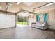Spacious garage with an open door, a comfortable seating area, and ample space for storage or projects at 29263 Sue Rd, Evergreen, CO 80439