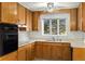 Kitchen with wood cabinets, double sink and ceiling fan at 11040 Emerson St, Northglenn, CO 80233