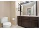 Bathroom features a mirror above the dark wood vanity with a white sink, a toilet, and neutral walls at 3237 W 113Th Ave, Westminster, CO 80031