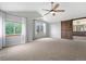 Spacious bedroom featuring a ceiling fan, two large windows, and an ensuite bathroom with a sliding wood door at 3237 W 113Th Ave, Westminster, CO 80031
