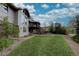 Expansive backyard featuring green grass, mature trees, and a brick patio for outdoor entertaining at 13959 W Cedar Pl, Golden, CO 80401