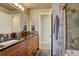 Bathroom featuring double sinks, granite countertops, and a tiled shower with modern fixtures at 13959 W Cedar Pl, Golden, CO 80401