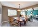 Cozy dining room featuring a wooden table, comfortable seating, and views of the bright living area at 13959 W Cedar Pl, Golden, CO 80401