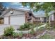 Charming brick home featuring a beautifully landscaped front yard with mature trees and a welcoming entrance at 13959 W Cedar Pl, Golden, CO 80401