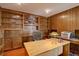 Cozy office with wood-paneled walls, custom built-in shelving, and a spacious desk for a productive workspace at 13959 W Cedar Pl, Golden, CO 80401