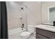 A beautifully tiled bathroom featuring a shower-tub, toilet, and a modern vanity at 6353 N Fulton St, Denver, CO 80238