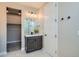 This bathroom features a sink with dark wood cabinets, modern lighting and closet at 6353 N Fulton St, Denver, CO 80238