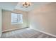 A simplistic bedroom space featuring neutral walls, carpeted floors, and a window with a view to the outside at 6353 N Fulton St, Denver, CO 80238