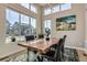 Well-lit dining area with a large wood table, surrounded by windows offering pleasant neighborhood views at 6353 N Fulton St, Denver, CO 80238