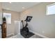 A Peloton exercise bike sits in a bright, compact room featuring neutral walls and carpeted floors at 6353 N Fulton St, Denver, CO 80238