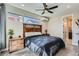 Bedroom features a queen bed with wood headboard, ceiling fan and window at 6353 N Fulton St, Denver, CO 80238